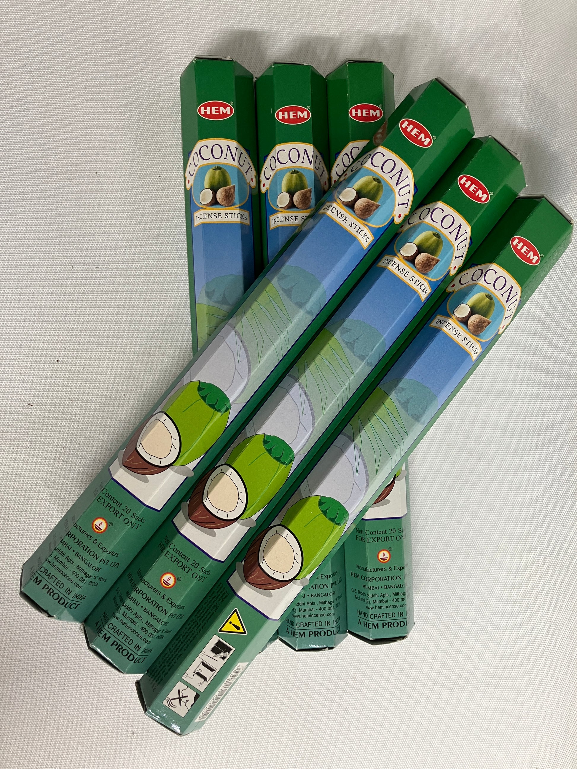 Stack of green HEMA coconut  incense packaging on a white background