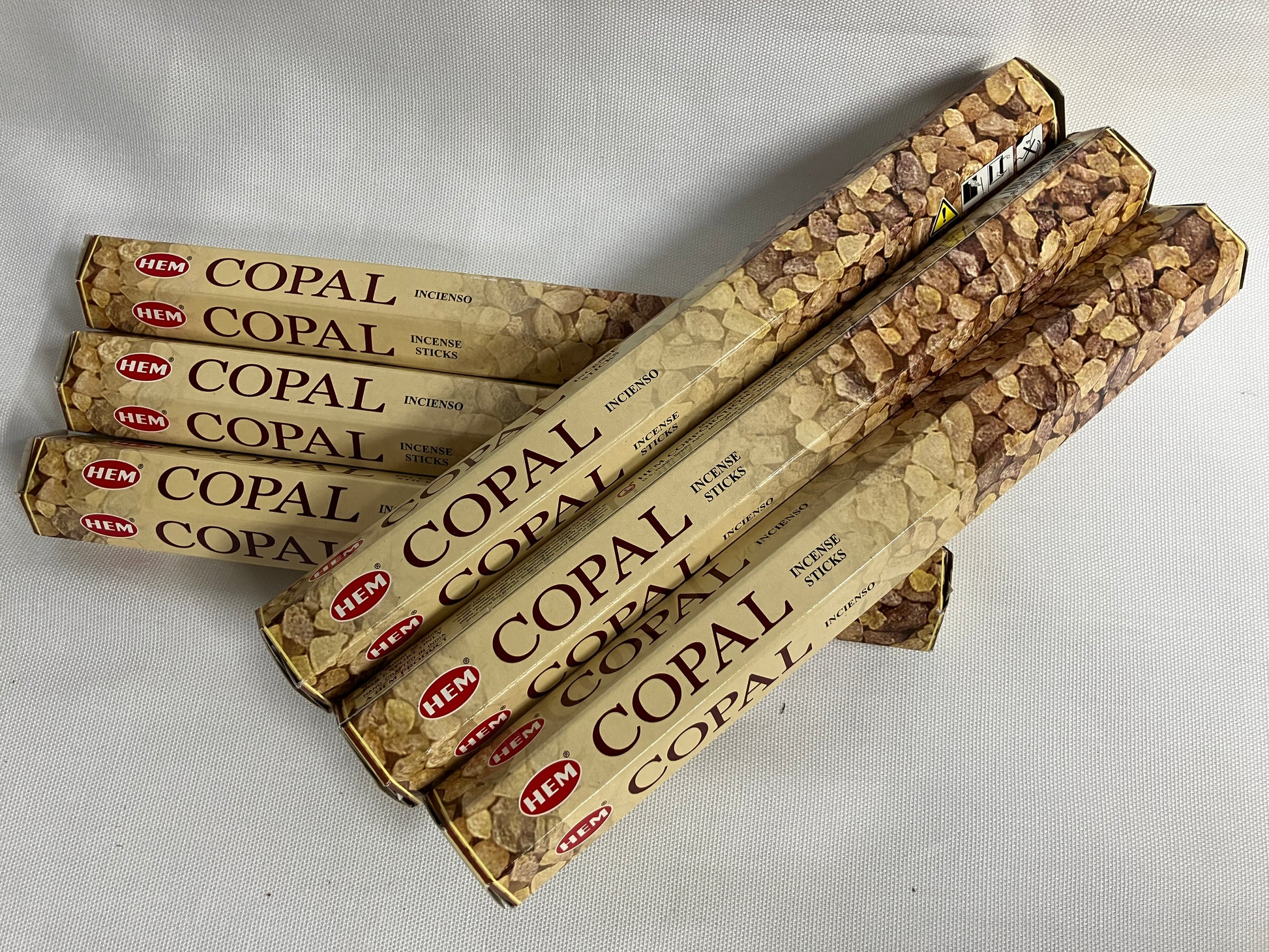 Multiple packages of HEM Copal incense sticks on a light gray background