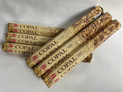 Multiple packages of HEM Copal incense sticks on a light gray background