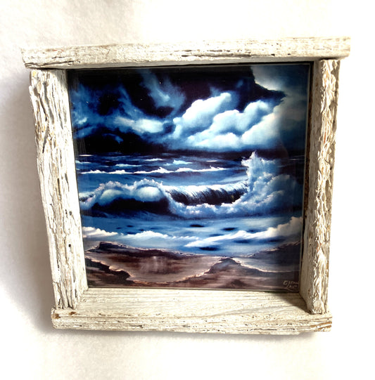 Framed artwork of a stormy sea with dark clouds and crashing waves.
