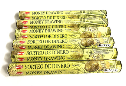 Multiple packages of HEM money drawing incense sticks shown in both English and Spanish  on a white background