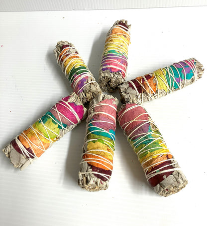 Colorful wrapped White Sage smudge sticks shown on a white background