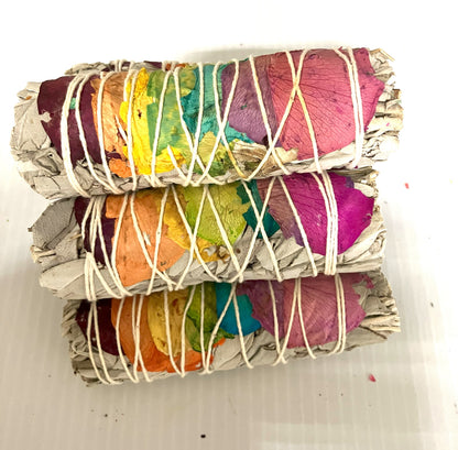 Stack of White Sage wrapped with colorful Rose Pedals and twine shown on a white background