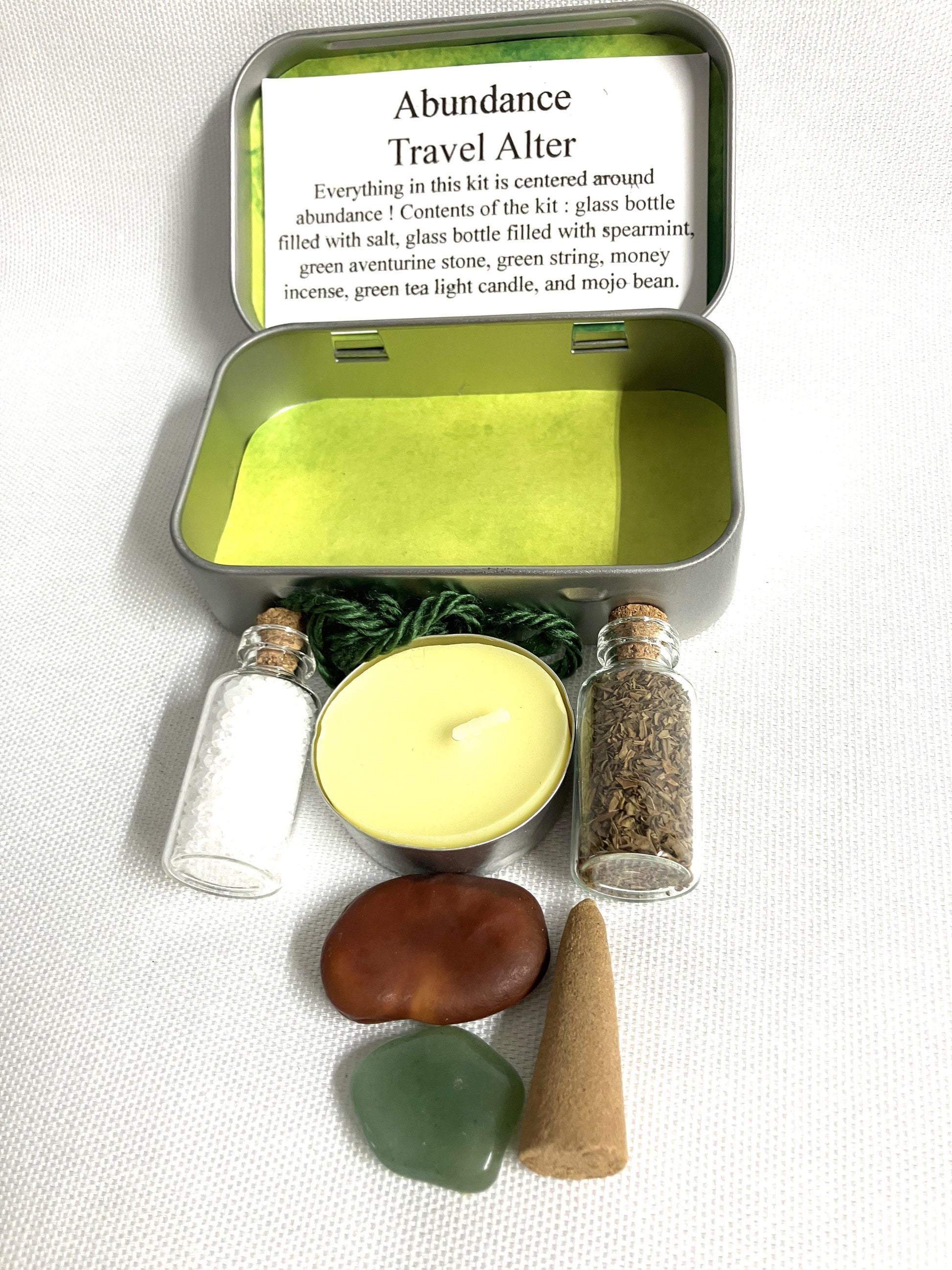 Abundance Travel Alter kit with various items in a tin box on a white background