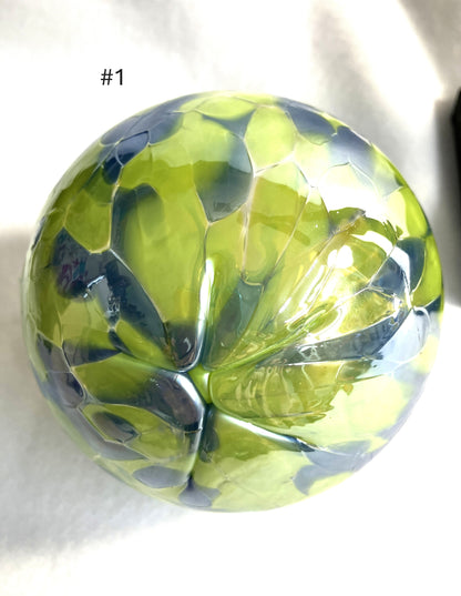 Green and blue faceted Blown Glass Witch Ball on a white background