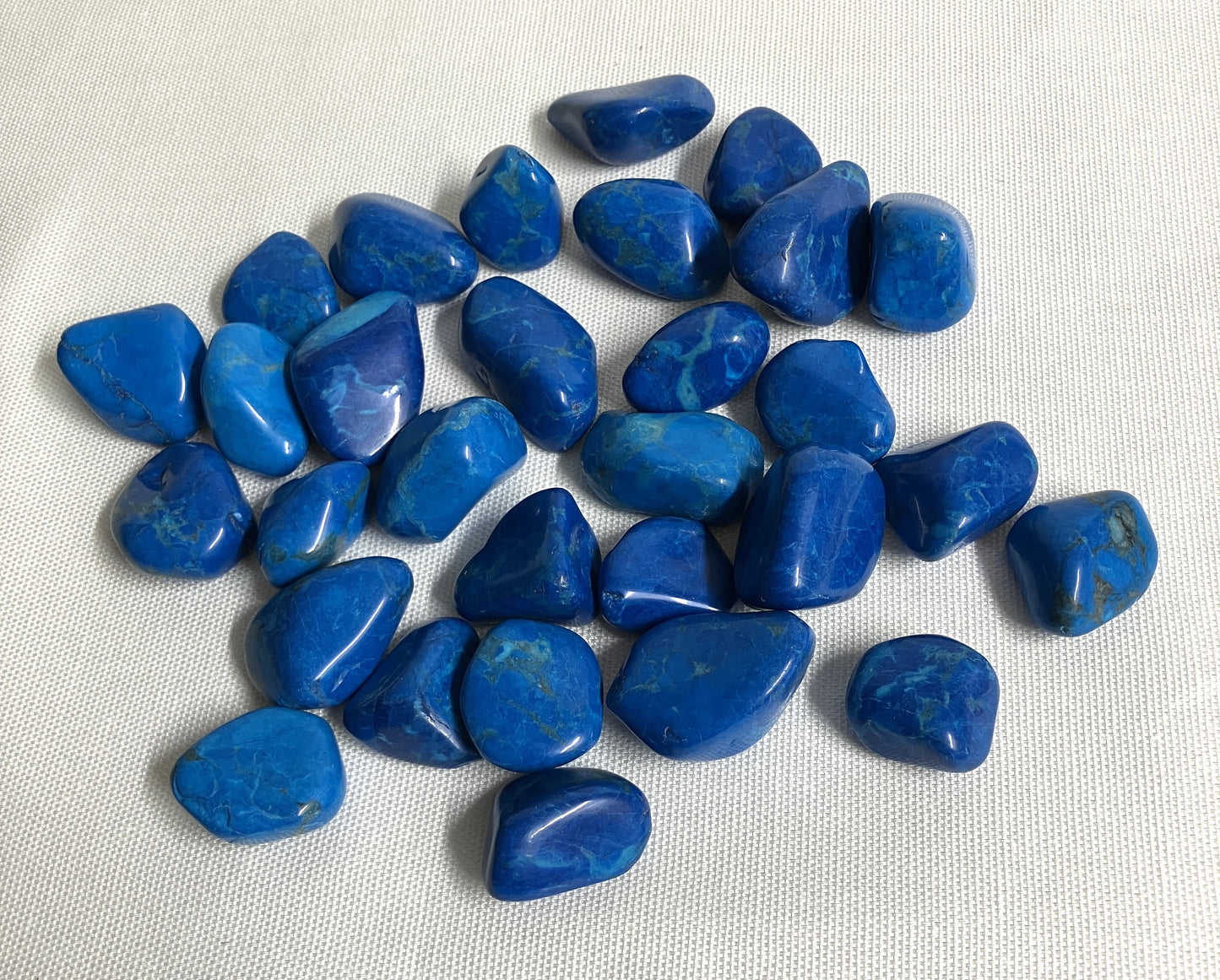 Front view of Dyed Blue Howlite Crystals on a white fabric background