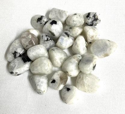 Tumbled Rainbow Moonstone Crystals  on a white fabric background
