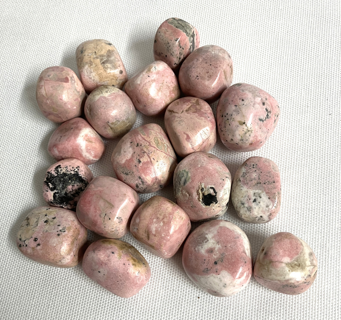 Group of Rhodochrosite Crystals on a white fabric background