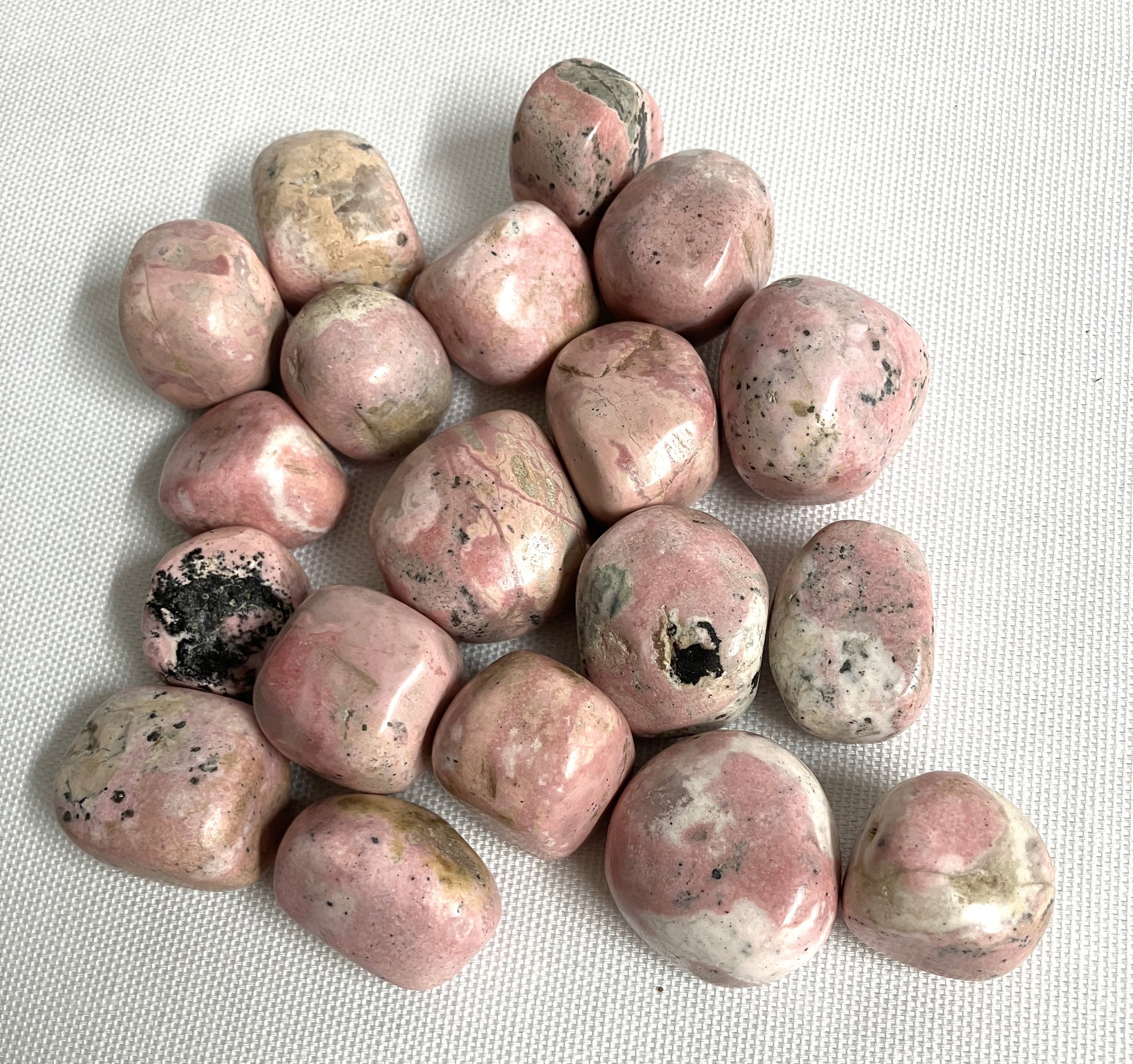 Group of Rhodochrosite Crystals on a white fabric background