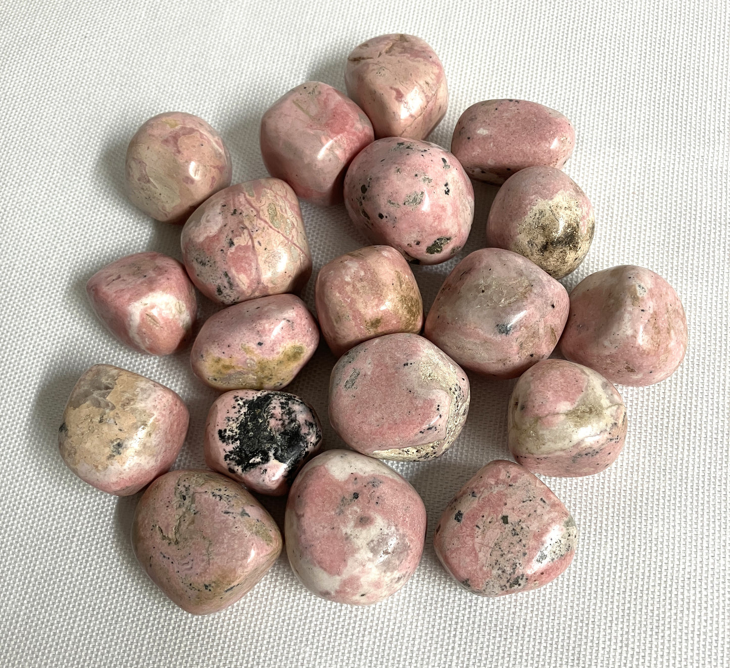 Back view of Rhodochrosite Crystals on a textured white surface