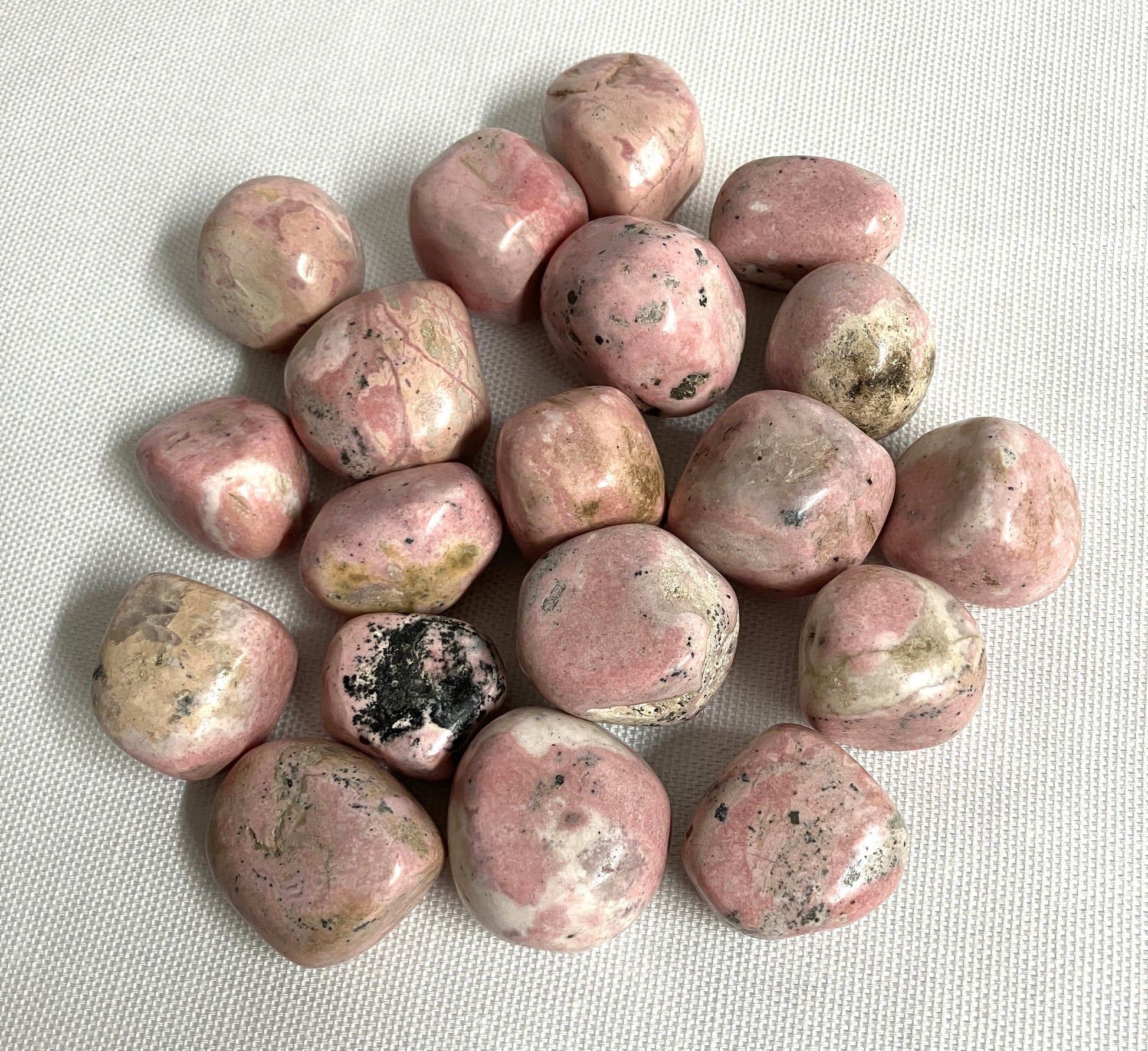 Back view of Rhodochrosite Crystals on a textured white surface