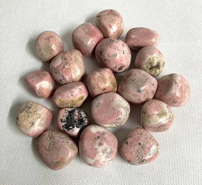 Back view of Rhodochrosite Crystals on a textured white surface