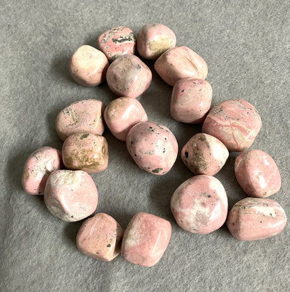 Front view of Rhodochrosite Crystals on a gray surface