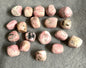 Assorted Rhodochrosite Crystals on a gray surface