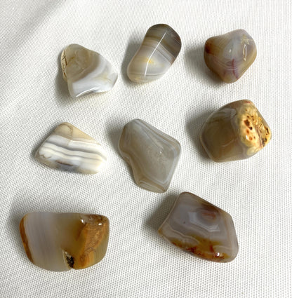 A group of Grey Banded Agate Crystals on a white fabric background