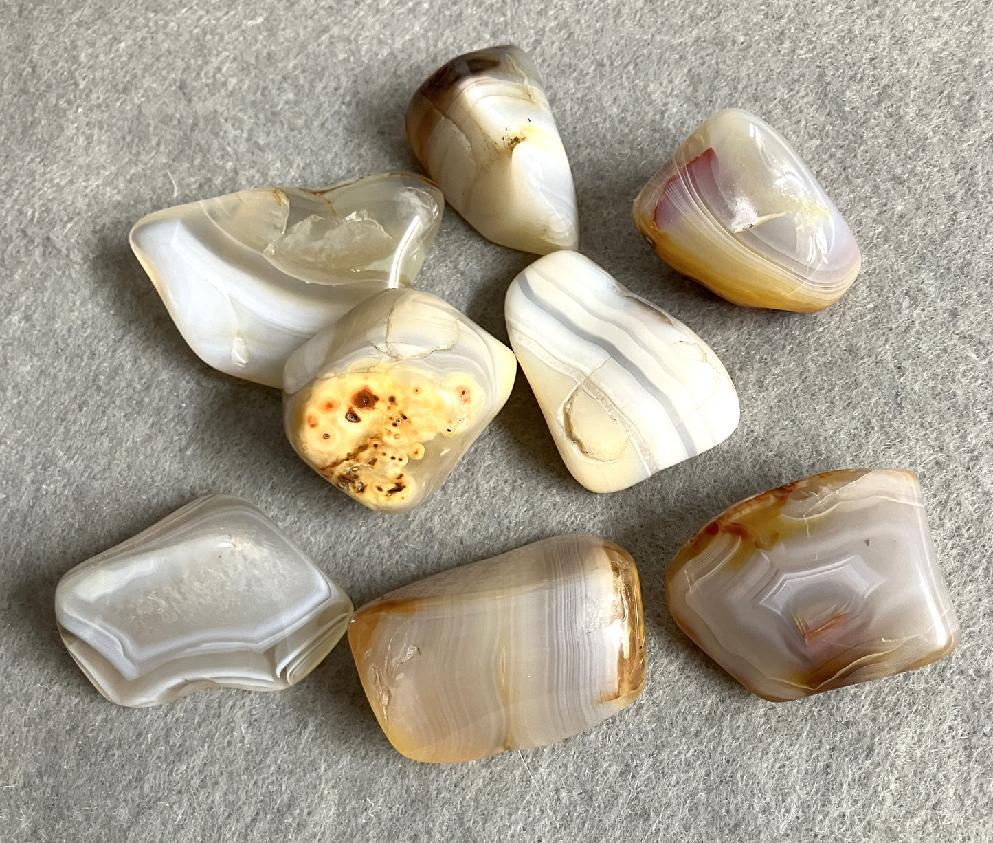 Bottom side view of Grey Banded Agate Crystals on a gray surface