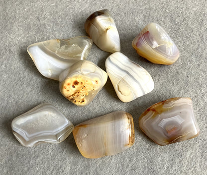Bottom side view of Grey Banded Agate Crystals on a gray surface