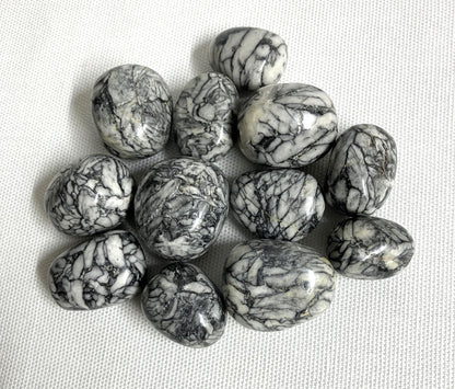 Tumbled Pinolith Jasper Crystals shown on a textured surface