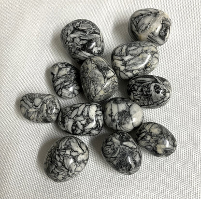 Collection of Pinolith Jasper Crystals on a textured beige surface