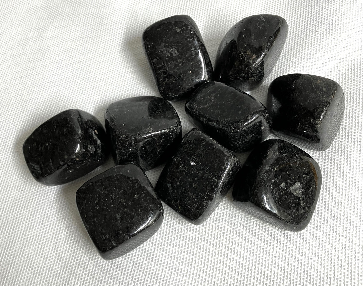 closeup of Nuummite Crystal AKA Sorcerers Stone on a white fabric background