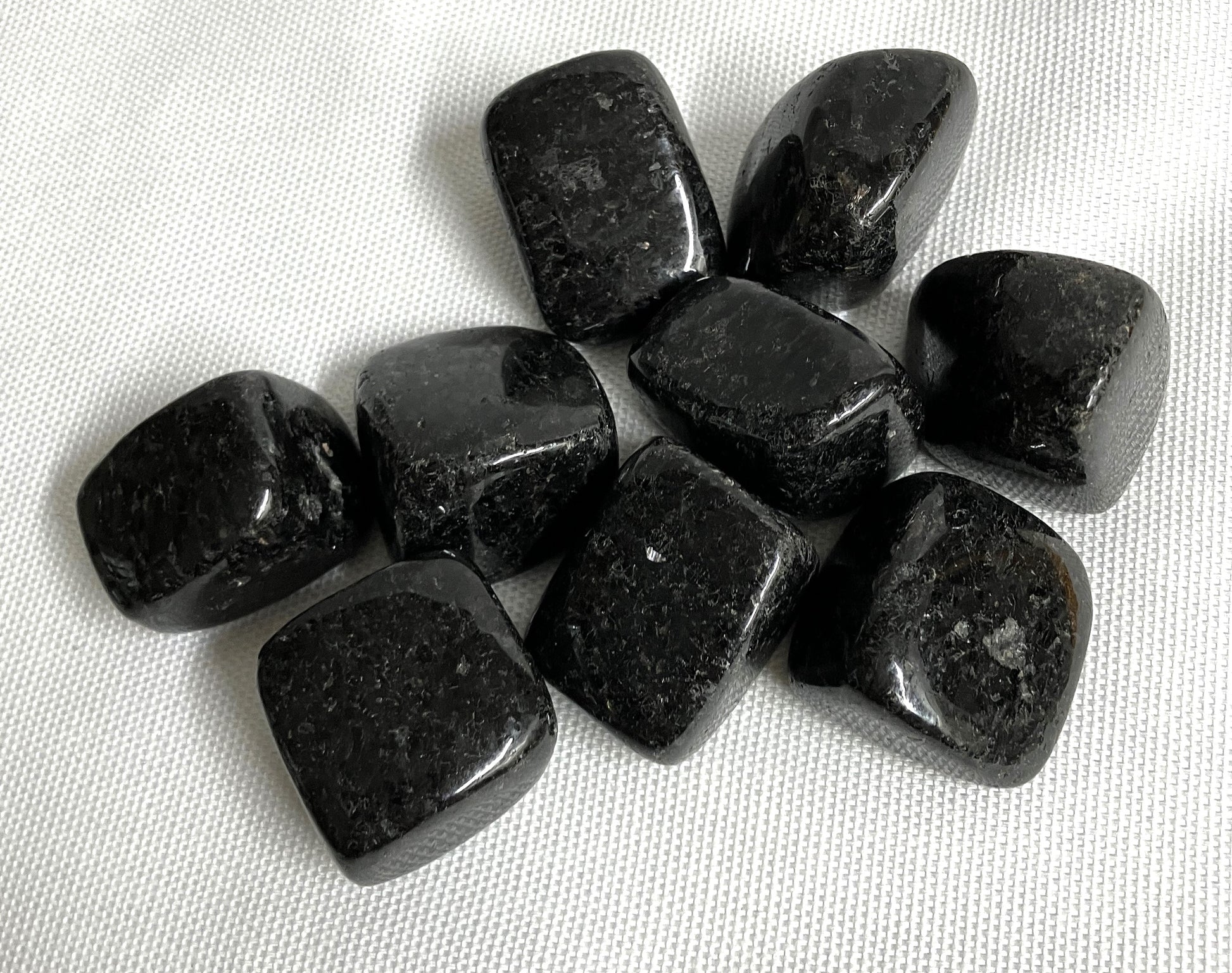closeup of Nuummite Crystal AKA Sorcerers Stone on a white fabric background