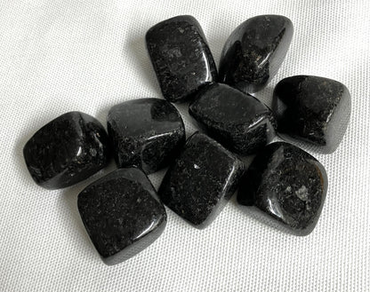 closeup of Nuummite Crystal AKA Sorcerers Stone on a white fabric background