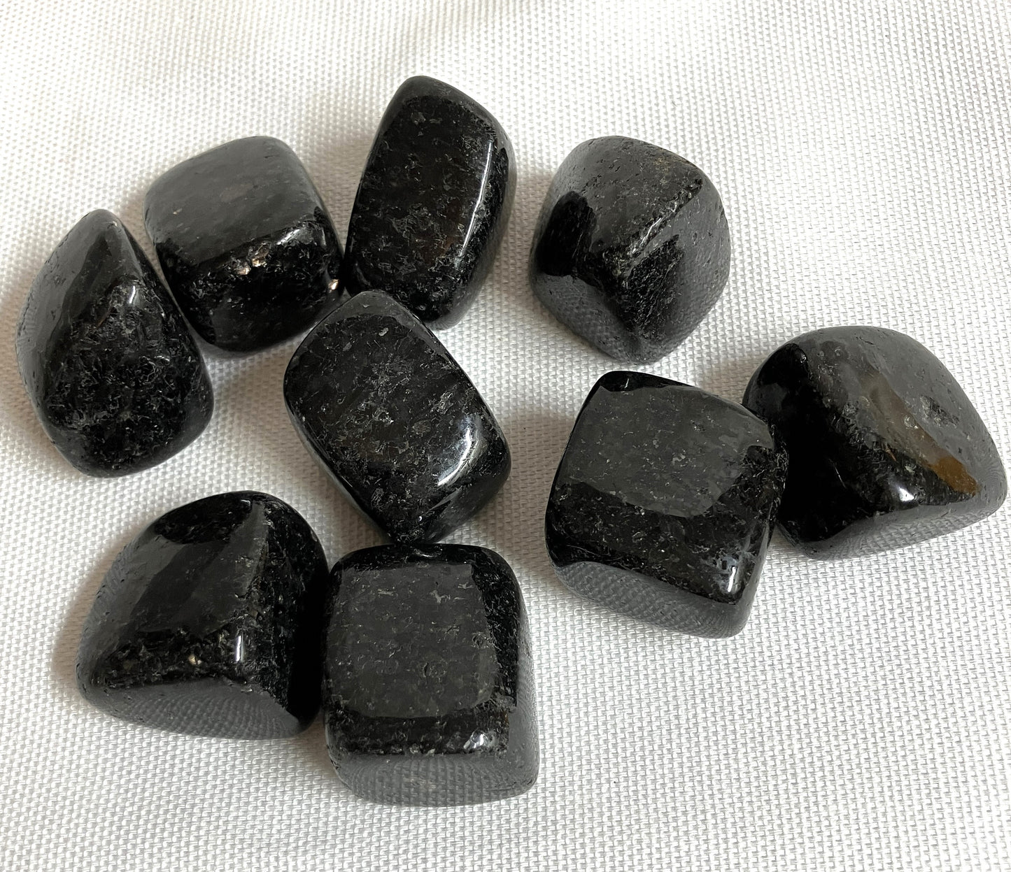 Nuummite Crystal AKA Sorcerers Stone displayed on a white fabric background