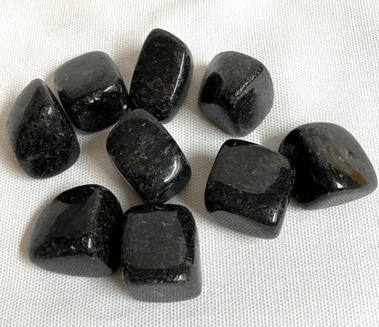 Nuummite Crystal AKA Sorcerers Stone displayed on a white fabric background