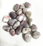 Pink Tourmaline Crystals showing the variations of color and pattern on a white background