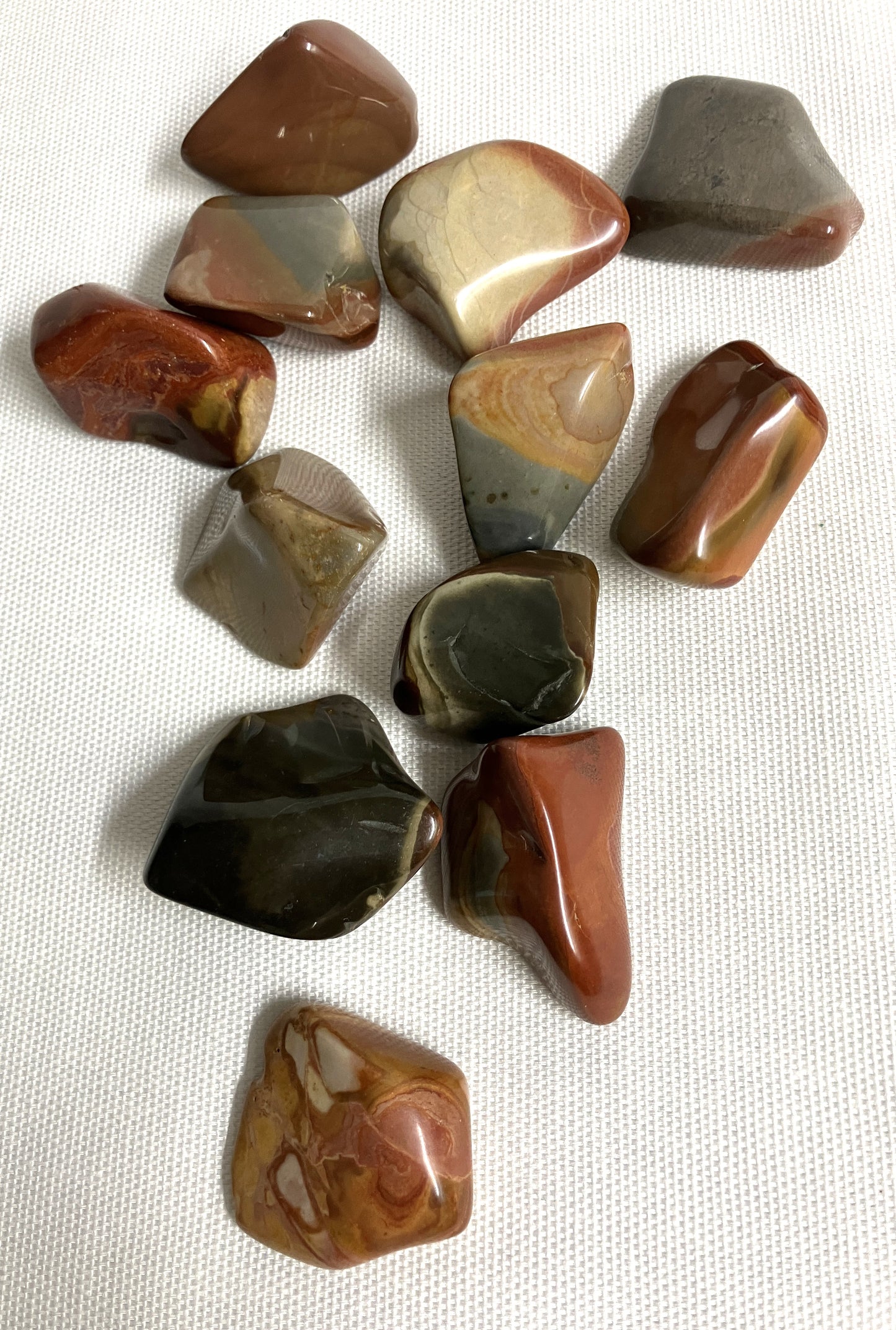 View 3 Desert Jasper Crystal AKA Polychrome Jasper  on a textured white surface