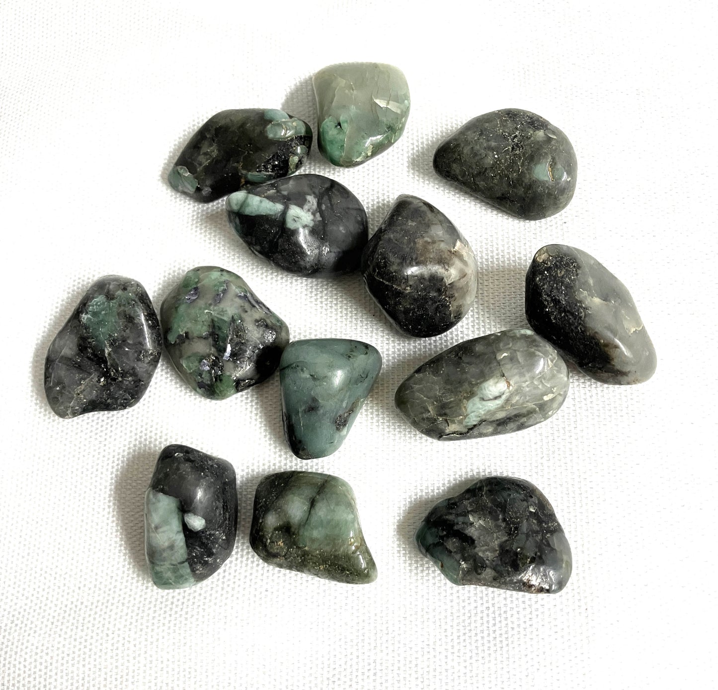 Group of Emerald Crystals  showing a different side on a white fabric background