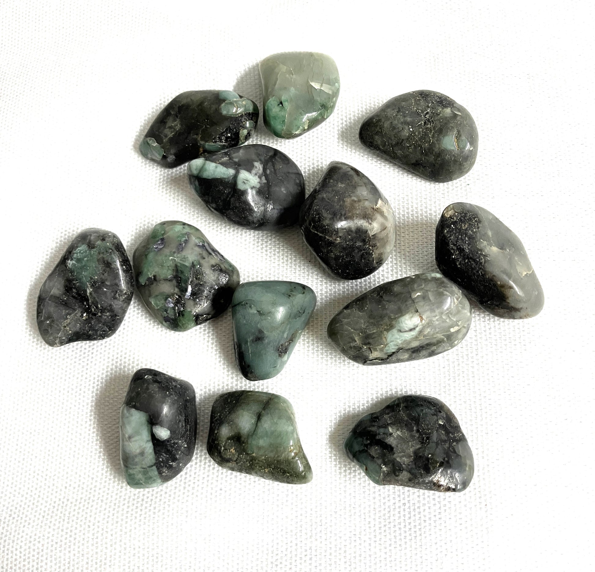 Group of Emerald Crystals  showing a different side on a white fabric background