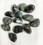 Collection of Emerald Crystals on a white fabric background front view