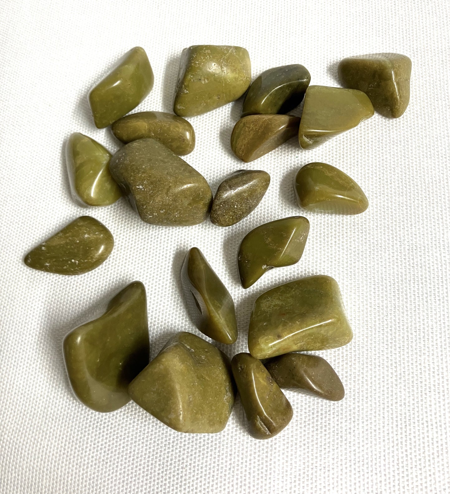 Top side of Green Opal Crystals on a white fabric background