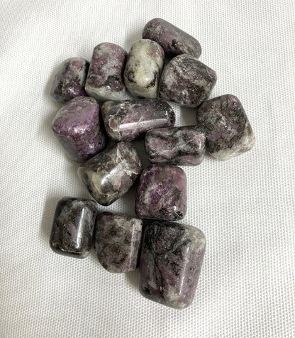 Bottom side of Pink Garnet Tumbled Crystals on a white fabric background