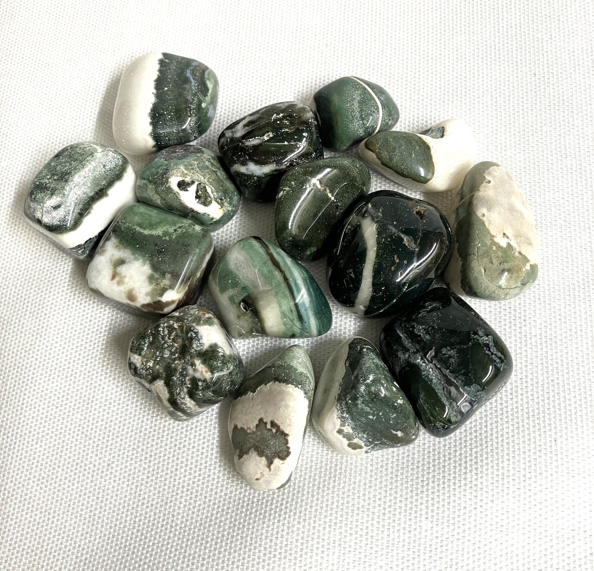 Closeup of Green Sardonyx Crystals on a white fabric background