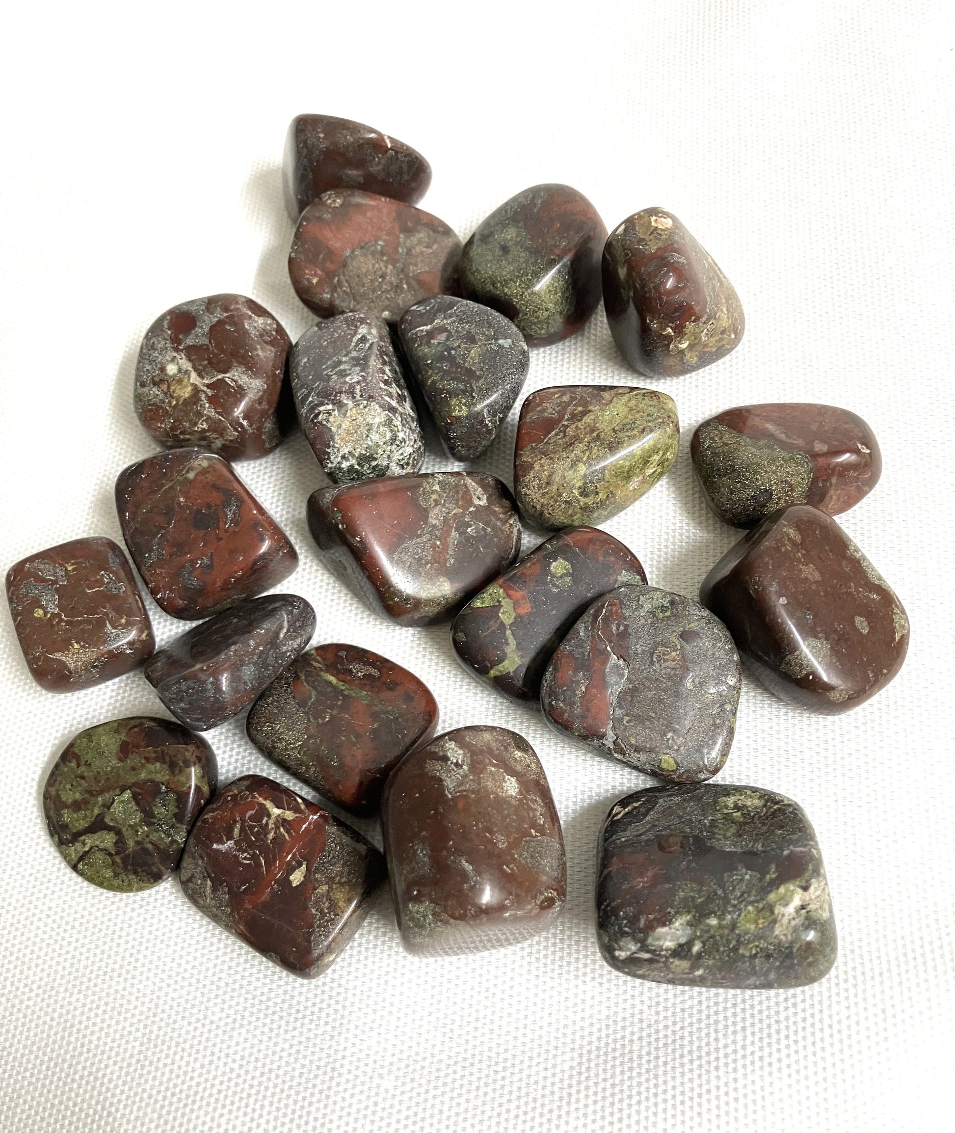 Collection of Dragons Blood Crystals showing the back side on a white fabric background