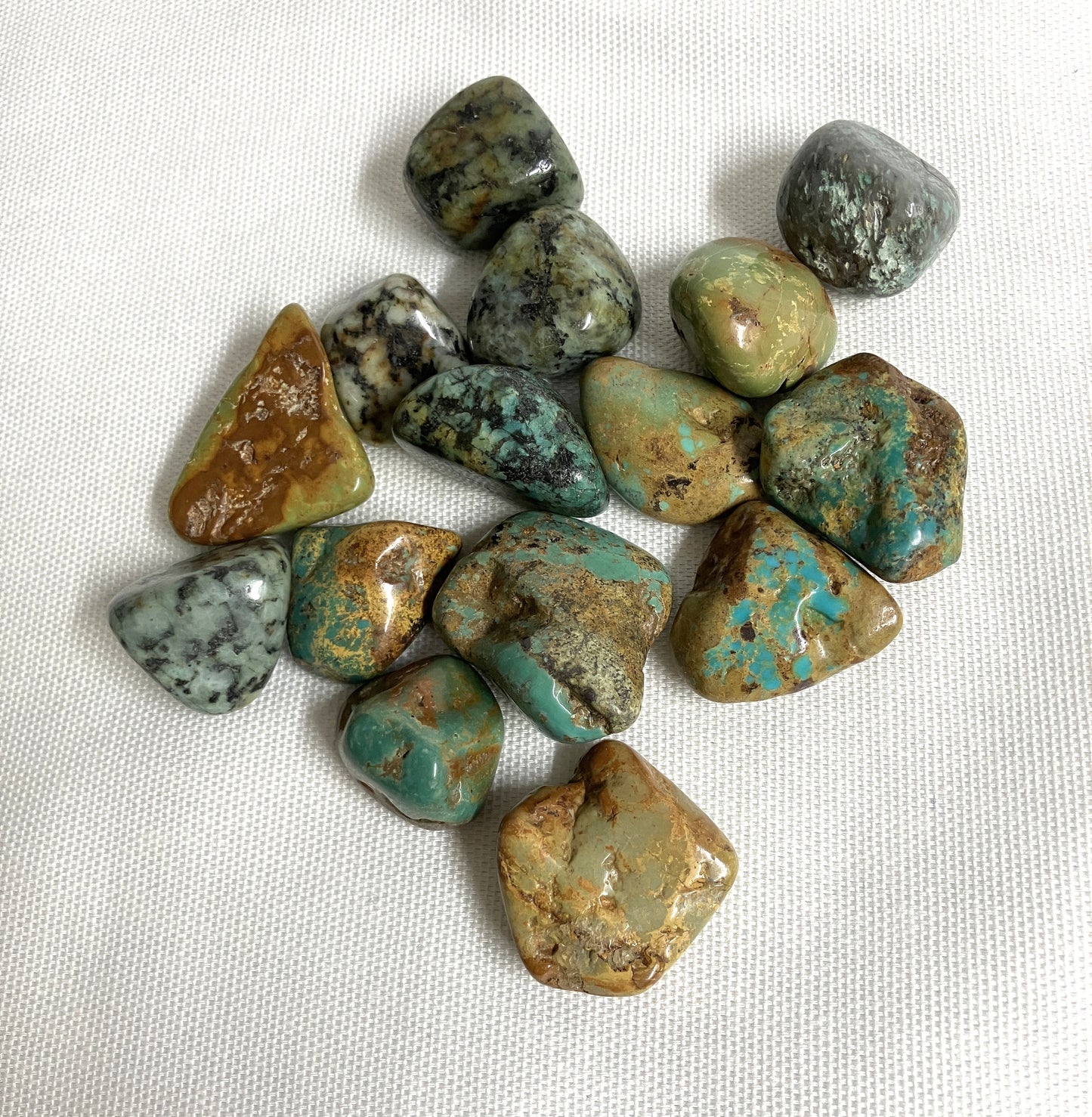 Front view of African Turquoise Crystals on a white fabric background