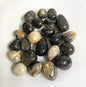 Collection of Feather Agate Tumbled Crystals on a white fabric background