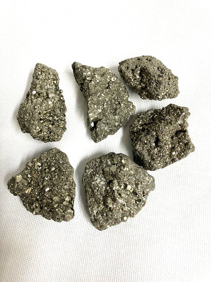 Closeup of Natural Pyrite Crystals AKA Fools Gold on a white fabric background