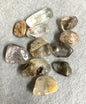 Collection of Lodolite Crystals AKA Garden Quartz on a gray surface