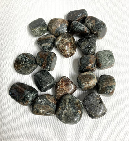 Green Garnet Crystals showing patterns and color on a white fabric background