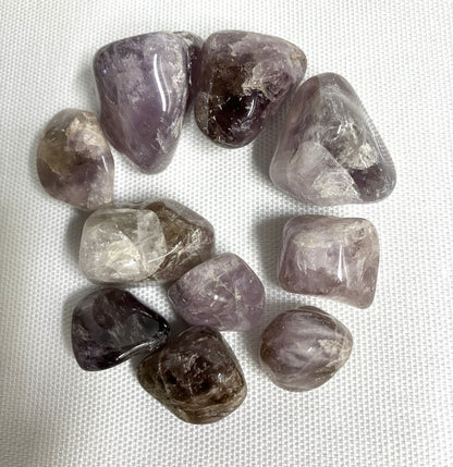 A grouping of Super Seven Crystals aka Melody's Stone on a white fabric background