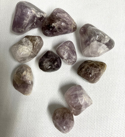 Collection of Super Seven Crystals aka Melody's Stone on a white fabric background