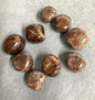 Front view of Hessonite Garnet Crystals on a gray surface