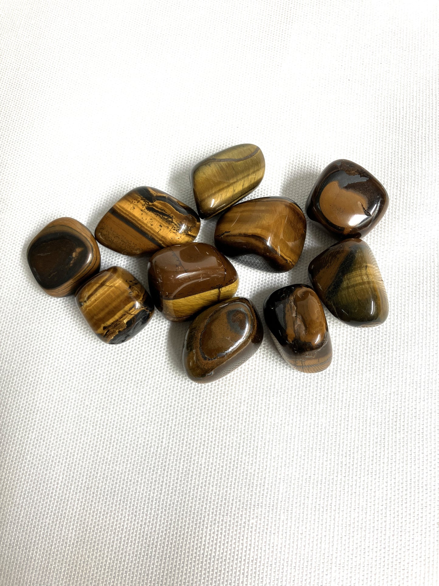 Back side of Yellow Tiger's Eye Crystals on a white fabric background