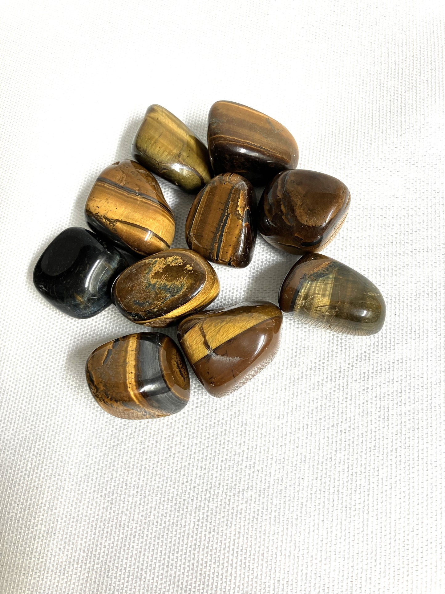 Front side of Yellow Tiger's Eye Crystals on a white fabric background
