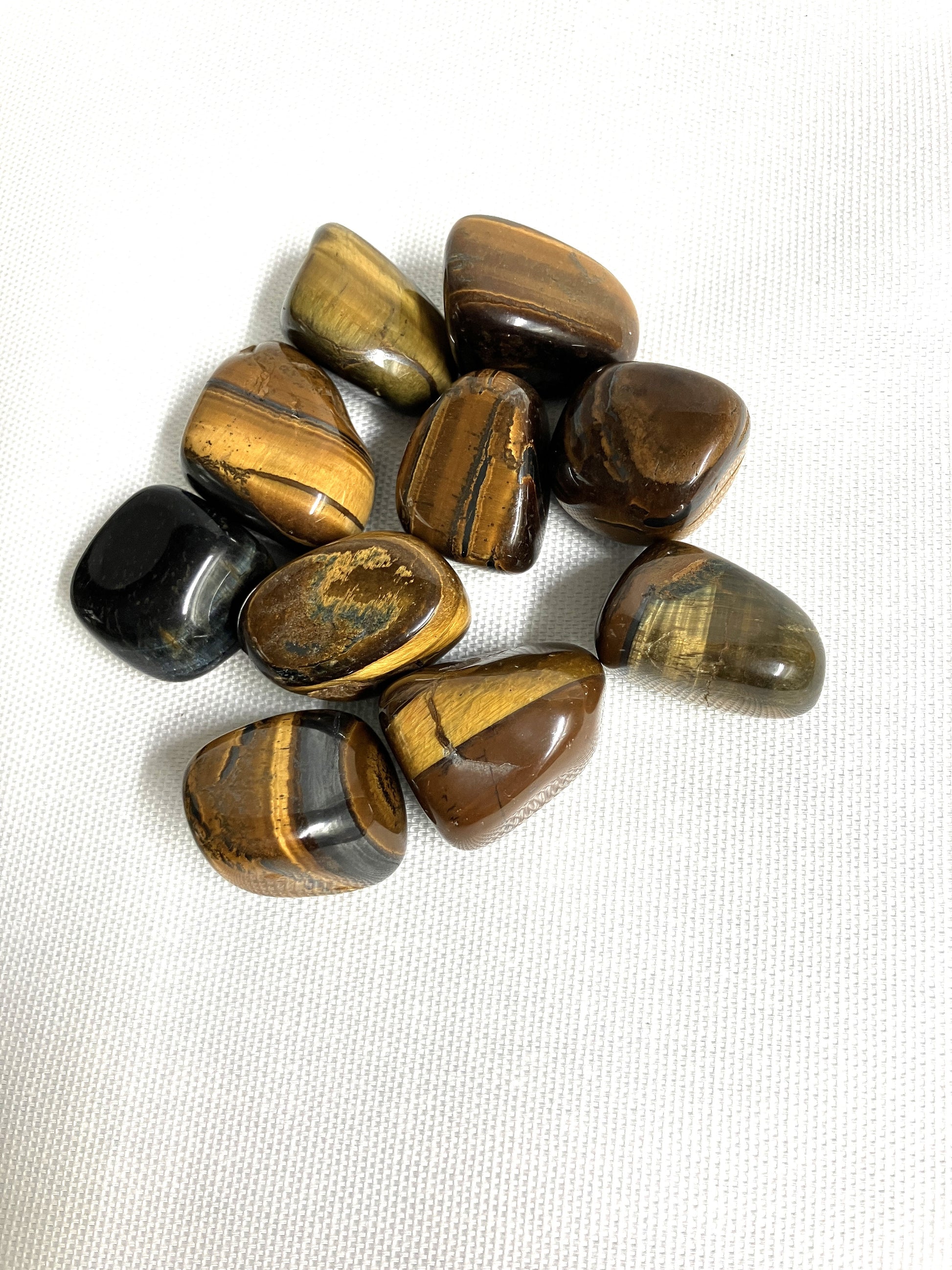 Front side of Yellow Tiger's Eye Crystals on a white fabric background