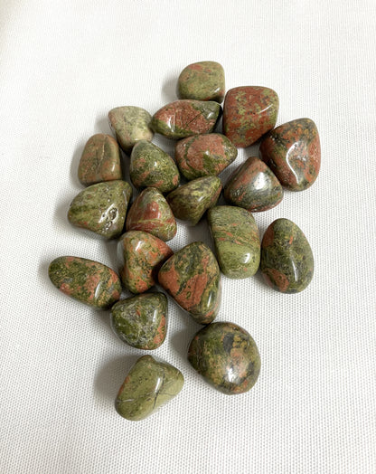 Back view of Unakite Crystal showing patterns and colors on a white fabric background