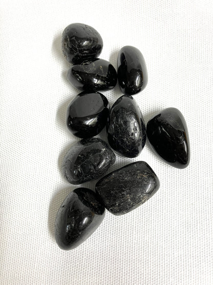 Black Tourmaline Crystals showing the front view on a white fabric background